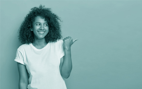 Mujer sonriendo mientras mira y señala al lado derecho.